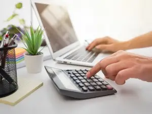 Business man using calculator with computer laptop